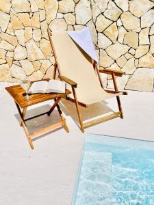 a chair with a book next to a swimming pool at City Apartments One in Mostar +43 photos