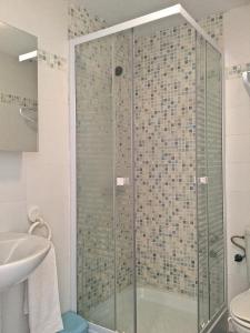 La salle de bains est pourvue d'une douche avec une porte en verre. dans l'établissement Velez Apartment, à Vélez de Benaudalla