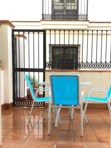 - deux chaises bleues et une table sur un balcon dans l'établissement Velez Apartment, à Vélez de Benaudalla