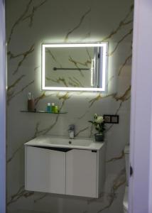 a bathroom with a white sink and a mirror at A e k a hotel Y V N in Yerevan +51 photos