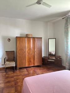 una camera da letto con un grande armadio in legno e una sedia di Vintage Home - monolocale in Salento a San Cassiano