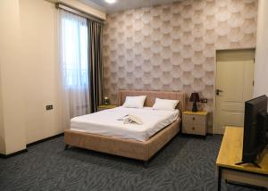 a hotel room with a bed and a television at A e k a hotel Y V N in Yerevan