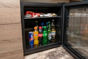 a refrigerator filled with different types of drinks at A e k a hotel Y V N in Yerevan
