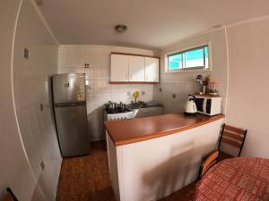 a small kitchen with a counter and a refrigerator at Cabañas Coquimbo in Coquimbo