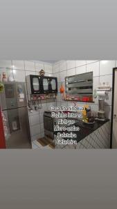 a kitchen with a refrigerator and a counter with words at Casa Rejane II Cop 30 in Ananindeua