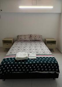 a bedroom with a bed with two towels on it at Apartamento comodo in Cali