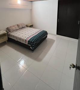 a bedroom with a bed and a tiled floor at Apartamento comodo in Cali