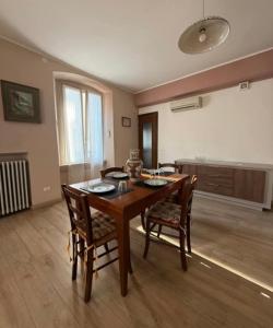 a dining room with a wooden table and chairs at Casa GILDA in Pisogne
