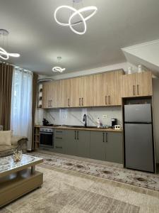 a kitchen with wooden cabinets and a refrigerator at Puka Retreat in Pukë