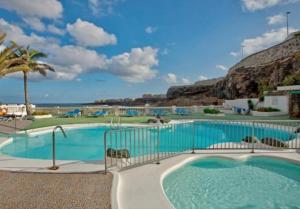 a large swimming pool with a view of the ocean at Apartamento Playa relax in La Estrella
