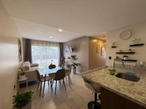 a kitchen and living room with a table and chairs at Tropical Sunshine in Alajuela