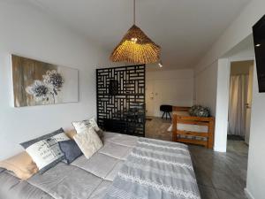 een woonkamer met een bank en een kroonluchter bij Alfonsina Departamento cerca del mar in Mar del Plata