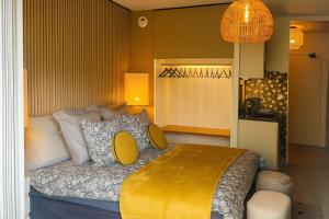 1 dormitorio con 1 cama con manta amarilla en Petit Cocon des Rives Proche Stanislas, en Nancy