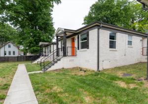 a small white house with an orange door at 2BR Haven 306C Close to Charlottes Uptown in Charlotte