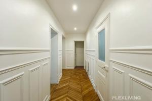 einen begehbaren Kleiderschrank mit weißen Wänden und Holzböden in der Unterkunft Cozy Room in Alésia Paris 14th in Paris