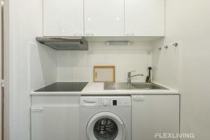 eine Küche mit Waschmaschine und Spüle in der Unterkunft Cozy Room in Alésia Paris 14th in Paris