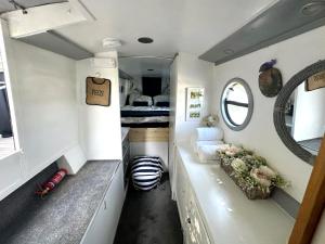 a tiny house with a bedroom and a bed at BrightOwl Waterside Narrowboat Cottage Experience in Thorpe