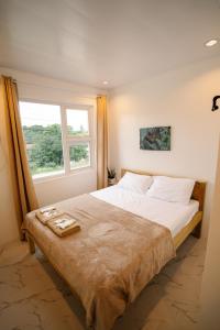 a bedroom with a large bed with a window at MGM Tourist Inn in Tagbilaran City