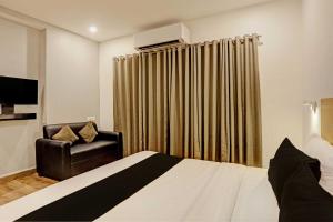 a hotel room with a bed and a chair at Super Townhouse Swain Heritage in Bhubaneshwar