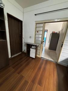 an empty room with a refrigerator and a door at Cantinho perto Unicamp in Campinas