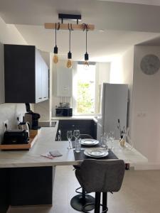 a kitchen with a table with plates and glasses on it at Appartement Premium - Le Trente in Dijon