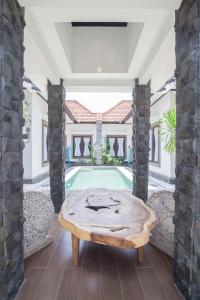 een woonkamer met een tafel en een zwembad bij Villa Marjens 2 Seminyak area Bali in Kerobokan