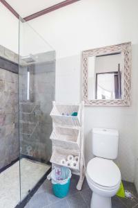 een badkamer met toilet en glazen douche bij Villa Marjens 2 Seminyak area Bali in Kerobokan +4 foto's