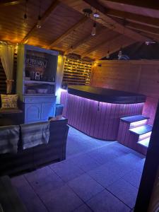 a bar in a restaurant with purple lighting at Domki KOLONIA LEŚNA z sauną i gorącą balią in Wünschelburg