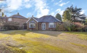 Bright & Cozy Countryside Bungalow في Tollerton: منزل به ساحة كبيرة أمامه