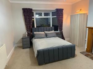 Bright & Cozy Countryside Bungalow في Tollerton: غرفة نوم بسرير كبير مع نافذة