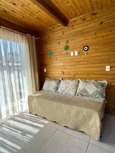 a bedroom with a bed and a wooden wall at Hospedagem Alecrim in Santo Amaro da Imperatriz