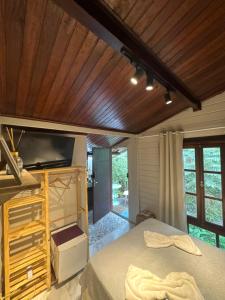 a bedroom with a bed and a flat screen tv at Apartamentos Ouro Verde in Angra dos Reis