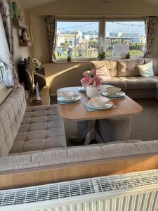 una sala de estar con una mesa y un sofá en Beech Rise, Primrose Valley, Filey, en Filey