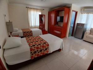 a hotel room with two beds and a television at Hotel Paseo Colon in Barranquilla +21 photos