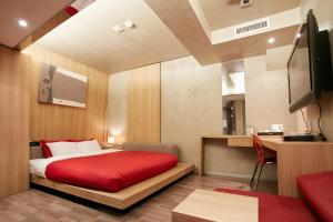 a hotel room with a red bed and a desk at Tria Business & Boutique Hotel in Seoul