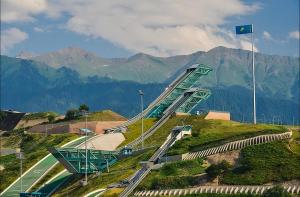 une route sinueuse sur une colline avec des montagnes en arrière-plan dans l'établissement Guest House, à Almaty