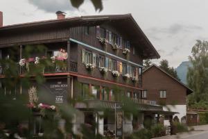 a woman is looking out the window of a building at Alpin & Wellness Resort Ludwig Royal in Oberstaufen