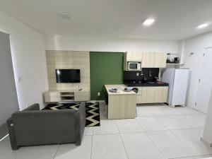 a kitchen with a couch and a kitchen with a refrigerator at Edifício Time - studios em Maceió in Maceió