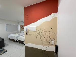 a room with a bed and a wall with a mural at Estúdios Time in Maceió