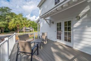 une terrasse couverte avec 2 chaises et une table sur une maison dans l'établissement James Island 1br Eco-haven Beachgolfdowntown!, à Charleston