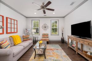 un salon avec un canapé et une télévision à écran plat dans l'établissement James Island 1br Eco-haven Beachgolfdowntown!, à Charleston