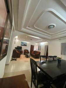 Un comedor y una sala de estar con mesa y sillas. en Nadida, en Lomé
