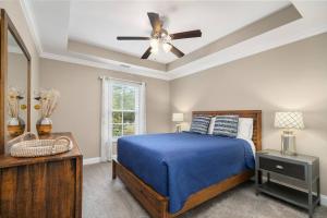 a bedroom with a blue bed and a ceiling fan at James Island 2br Eco-haven Beachgolfdowntown! in Charleston