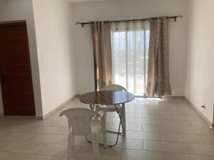 a dining room with a table and chairs and a window at Un logement spacieux in Toamasina