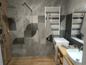 a bathroom with a shower and a sink at APART FLOW Walendów Park in Nadarzyn