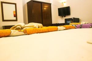 a long yellow and white blanket on a bed at Flamingo Memnon Guest House in Luxor