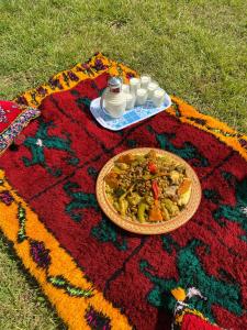 a plate of food on a rug on the grass at منتزه السلامة Parc ASSALAMA in Kenitra