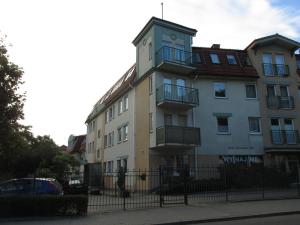 um edifício com uma cerca em frente em Apartament Mundus em Sopot