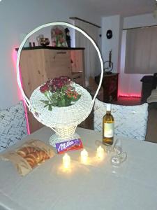 a table with a vase with flowers and a bottle of wine at Vacances en tout tranquillité à Vercorin in Vercorin