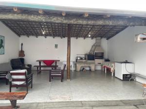 a living room with a table and chairs at Casa com piscina in Ilhabela